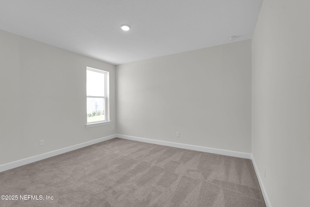 empty room with carpet and baseboards