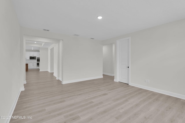 unfurnished room featuring light wood finished floors, baseboards, and recessed lighting