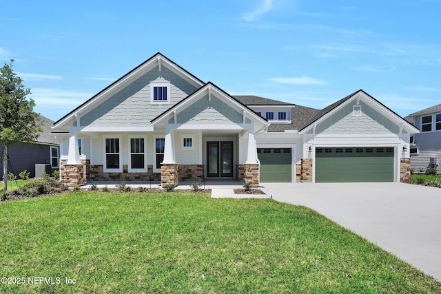 craftsman-style house with a garage, stone siding, a front lawn, and concrete driveway