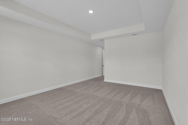 unfurnished room with carpet floors, baseboards, a raised ceiling, and recessed lighting
