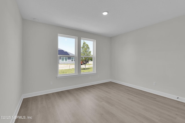 unfurnished room featuring wood finished floors and baseboards
