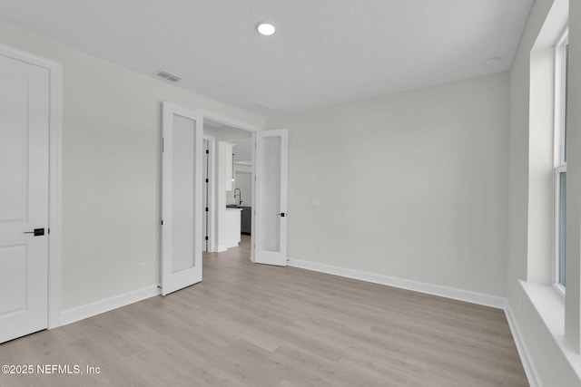 unfurnished bedroom with light wood-style flooring, baseboards, and recessed lighting