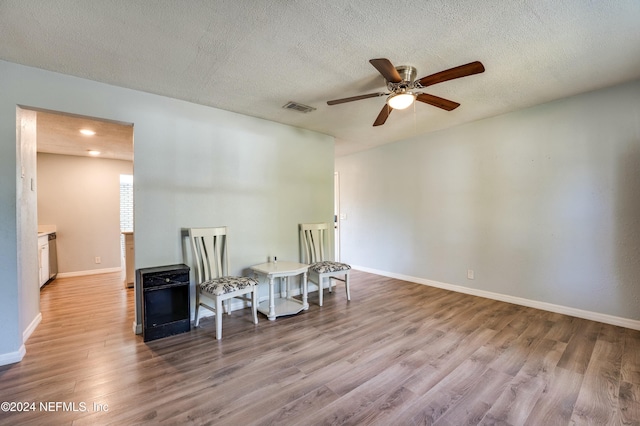 sitting room with a textured ceiling and light hardwood / wood-style flooring