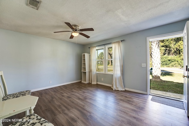 spare room featuring a textured ceiling, ceiling fan, and dark wood-type flooring