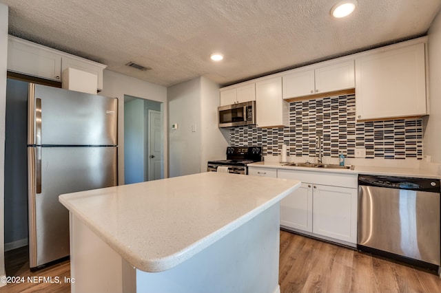 kitchen featuring a center island, stainless steel appliances, white cabinetry, and sink