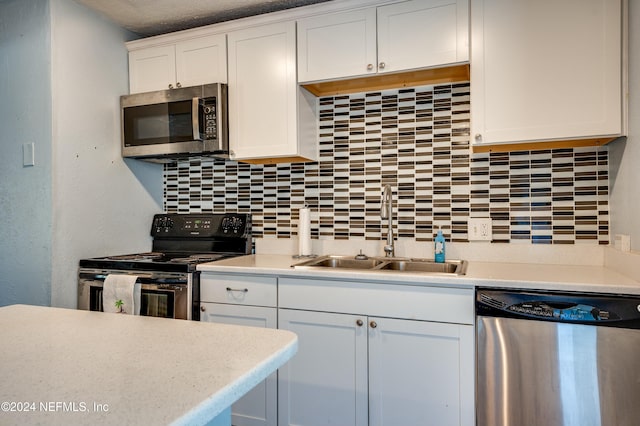 kitchen with sink, decorative backsplash, a textured ceiling, white cabinetry, and stainless steel appliances