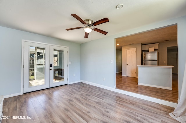 spare room with ceiling fan, french doors, a textured ceiling, and light wood-type flooring