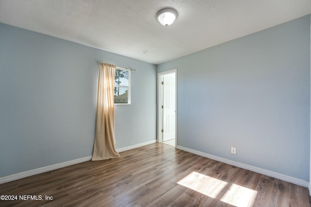 empty room featuring hardwood / wood-style floors and a textured ceiling