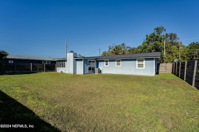 rear view of property featuring a yard