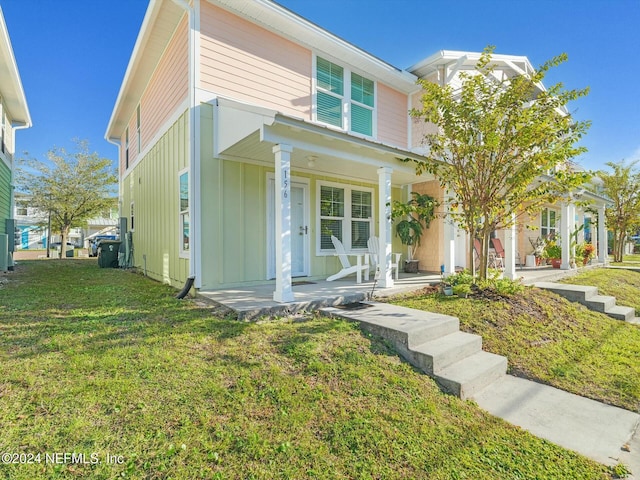 156 Sandy Beach Ln, Atlantic Beach, FL 32233 - view of front of house with board and batten siding, covered porch, and a front yard