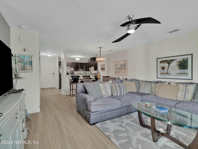 living room with light hardwood / wood-style floors and ceiling fan