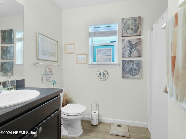 bathroom with a shower with curtain, hardwood / wood-style flooring, toilet, and vanity