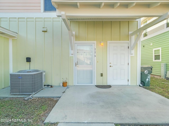 doorway to property with cooling unit and a patio