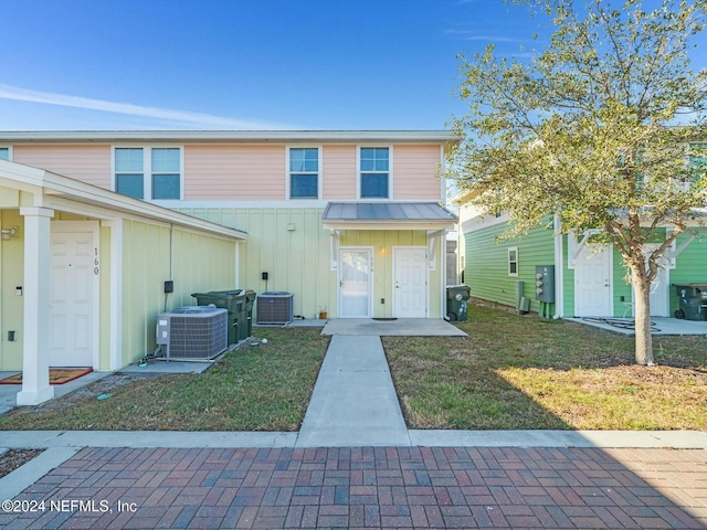 view of front of house featuring a front lawn and central air condition unit