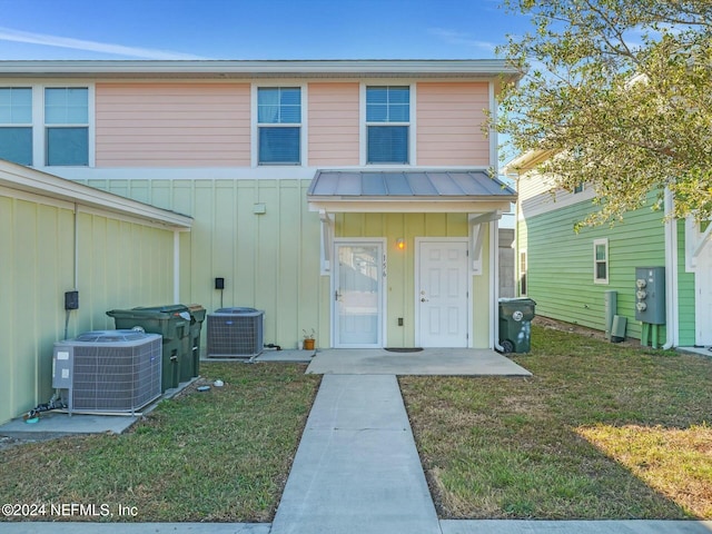 view of front of house featuring a front yard and central air condition unit