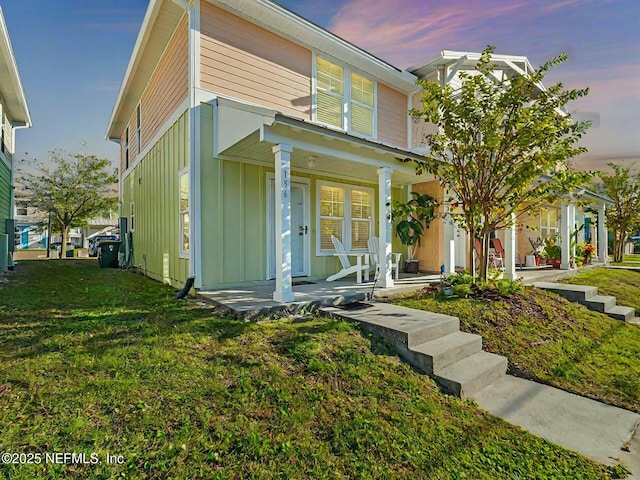 view of front of house with covered porch and a yard