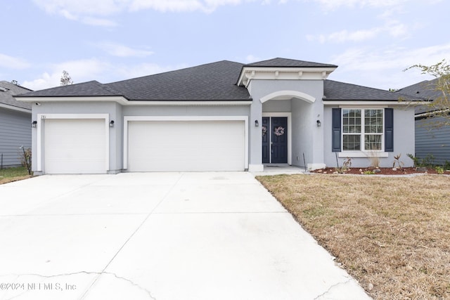 view of front of home with a garage and a front lawn