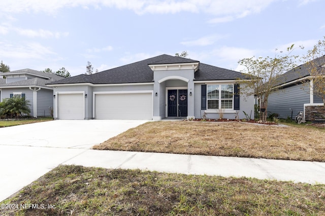 view of front of home with a front lawn and a garage