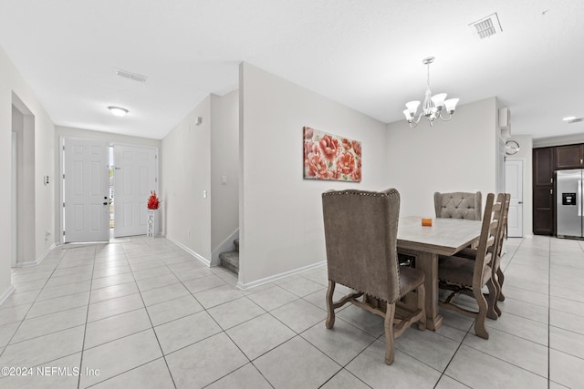 tiled dining room featuring a chandelier