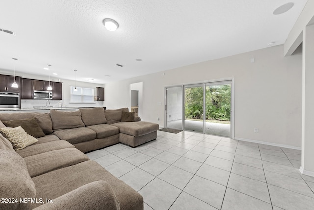 tiled living room featuring a textured ceiling