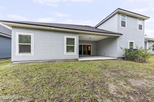 rear view of property featuring a patio area and a lawn