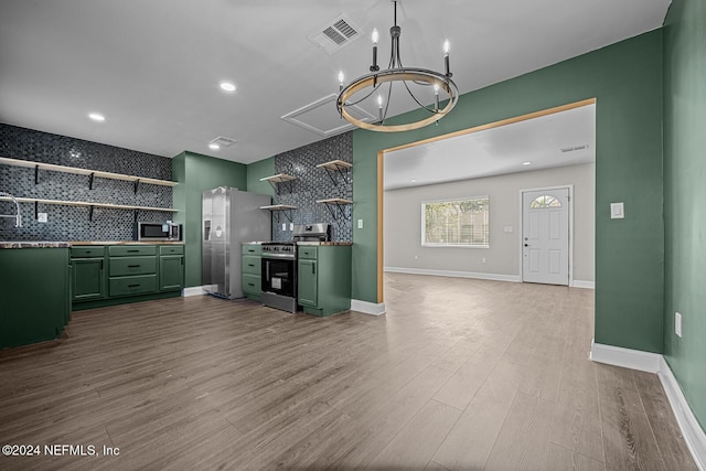 kitchen featuring backsplash, light hardwood / wood-style flooring, stainless steel appliances, and green cabinetry