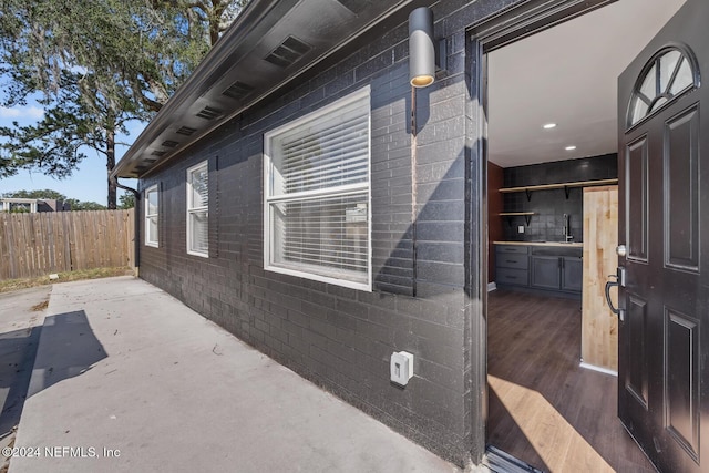 view of side of home with sink and a patio