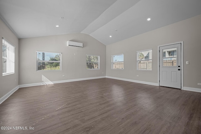 unfurnished living room featuring a wall mounted air conditioner, dark wood-type flooring, and a wealth of natural light