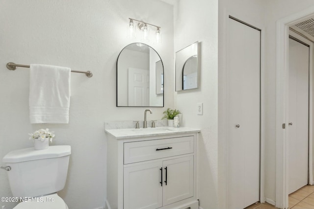 bathroom featuring vanity, tile patterned flooring, and toilet