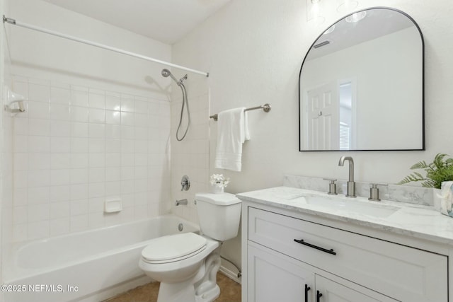 full bathroom with tiled shower / bath, vanity, and toilet