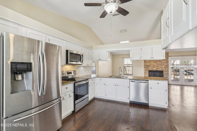 kitchen featuring stone counters, stainless steel appliances, white cabinetry, and sink