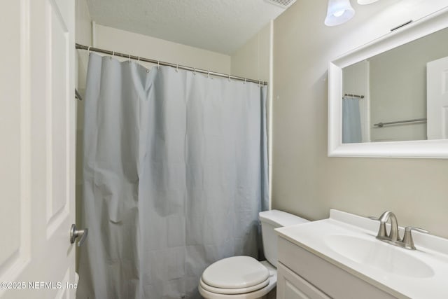 bathroom with vanity, a shower with shower curtain, a textured ceiling, and toilet