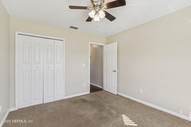 unfurnished bedroom featuring carpet flooring, ceiling fan, and a closet