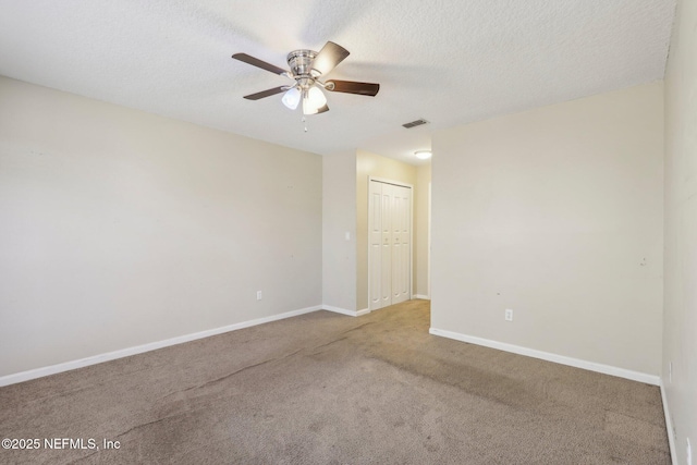 carpeted spare room with ceiling fan and a textured ceiling