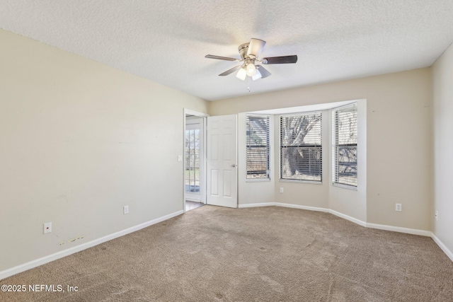 carpeted empty room featuring ceiling fan and a textured ceiling