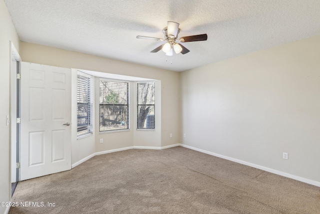 carpeted empty room with ceiling fan and a textured ceiling