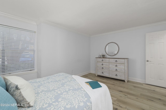 bedroom with crown molding and light hardwood / wood-style floors