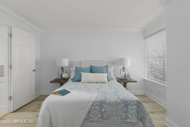 bedroom featuring light wood-type flooring and crown molding