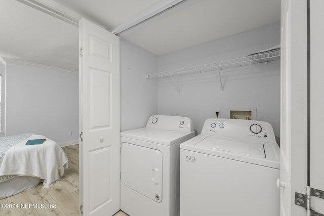 laundry room featuring light hardwood / wood-style floors, independent washer and dryer, and crown molding