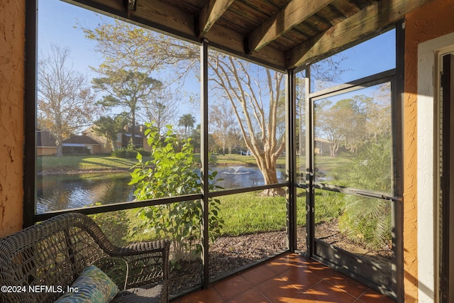 unfurnished sunroom with beam ceiling, a water view, and wood ceiling