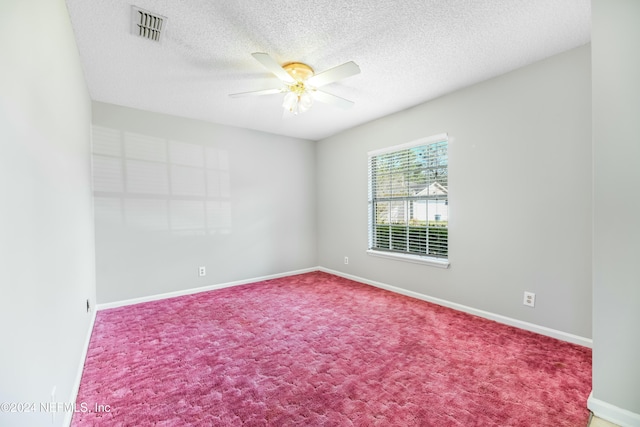 empty room featuring ceiling fan, carpet, and a textured ceiling