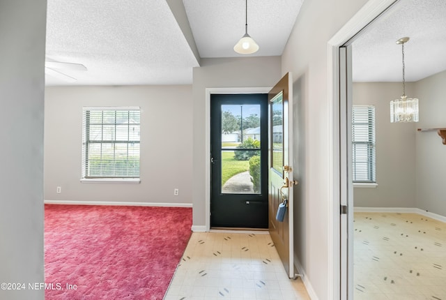 doorway to outside with a textured ceiling