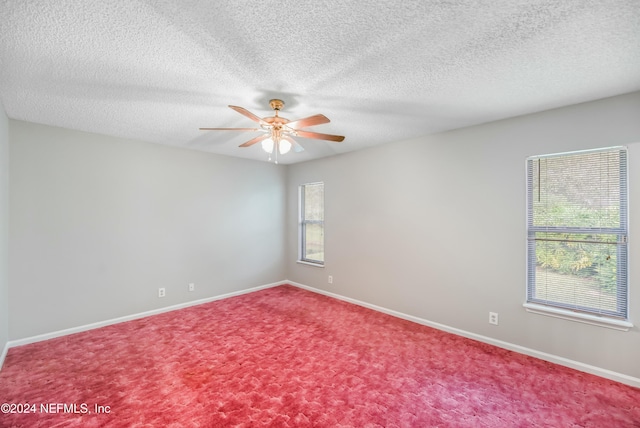 carpeted spare room with a textured ceiling and ceiling fan