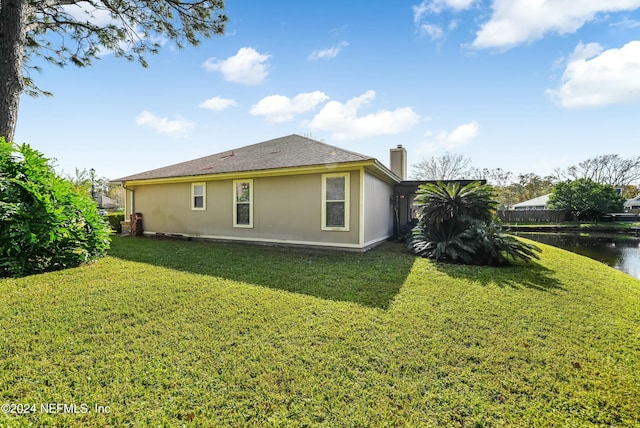 view of side of property with a lawn and a water view