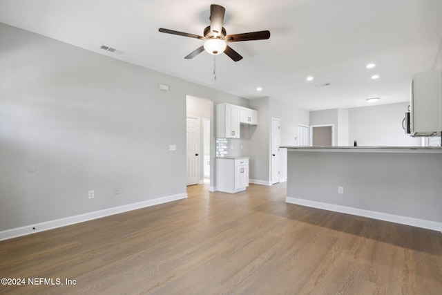 unfurnished living room with ceiling fan and light wood-type flooring