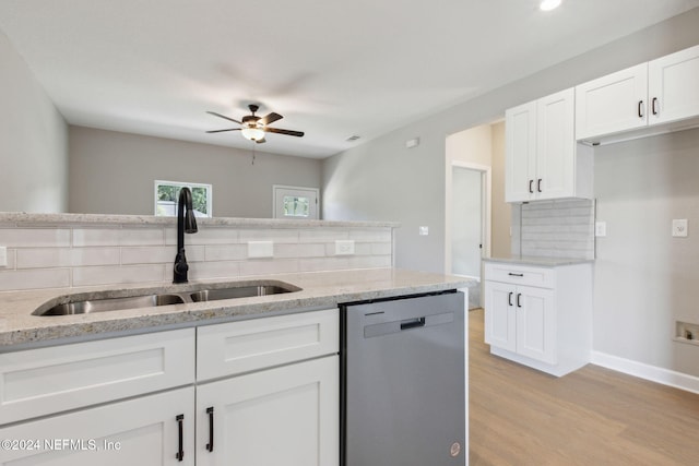 kitchen featuring white cabinetry, decorative backsplash, light stone countertops, stainless steel dishwasher, and sink