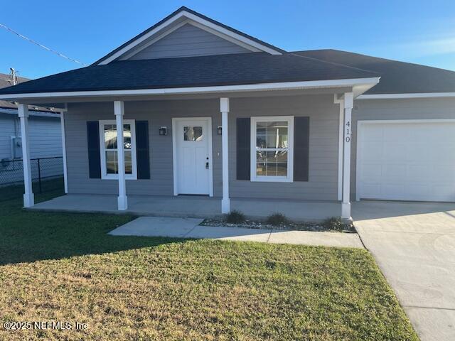 ranch-style house with a front yard, covered porch, and a garage