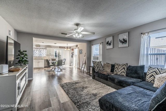 living room with hardwood / wood-style floors, ceiling fan, a textured ceiling, and a wealth of natural light