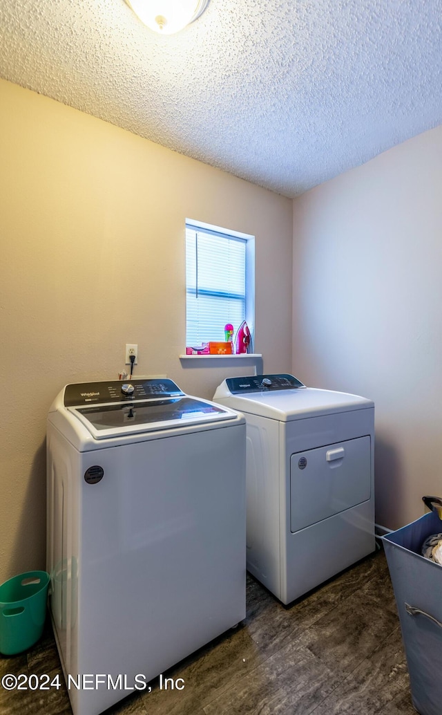 washroom with separate washer and dryer, dark wood-type flooring, and a textured ceiling