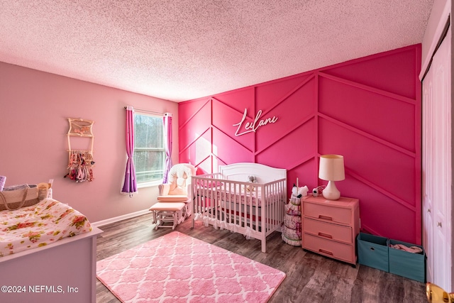 bedroom featuring a closet, wood-type flooring, and a nursery area